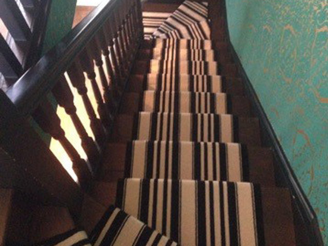 Medium sized classic carpeted straight wood railing staircase in London with carpeted risers.
