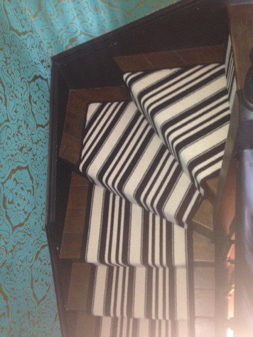 ロンドンにある中くらいなトランジショナルスタイルのおしゃれな直階段 (カーペット張りの蹴込み板、木材の手すり) の写真