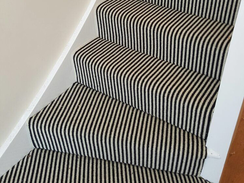 ロンドンにあるエクレクティックスタイルのおしゃれな折り返し階段 (カーペット張りの蹴込み板) の写真
