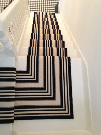 Photo of a medium sized contemporary carpeted u-shaped wood railing staircase in London with carpeted risers.