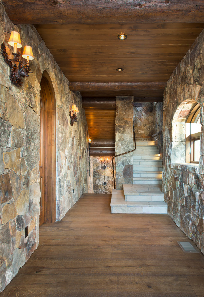 This is an example of a medium sized rustic wood u-shaped staircase in Denver with wood risers.