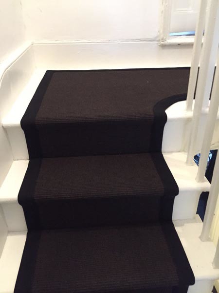 Photo of a medium sized contemporary carpeted u-shaped wood railing staircase in London.