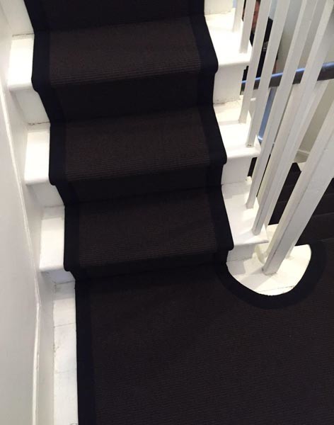 Foto de escalera en U actual de tamaño medio con escalones enmoquetados y barandilla de madera