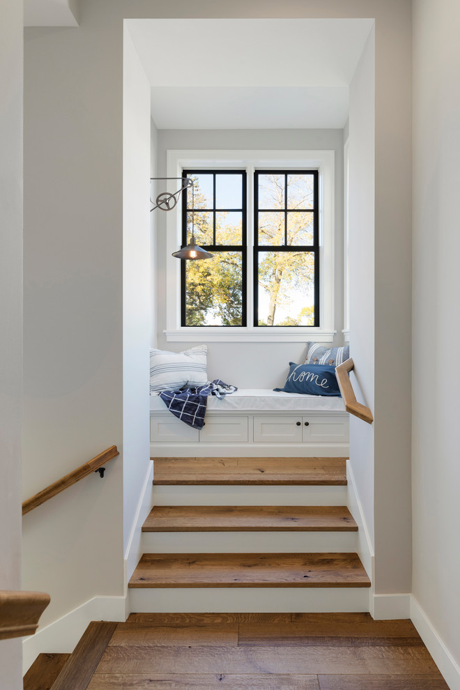 Стильный дизайн: лестница в морском стиле с деревянными ступенями, крашенными деревянными подступенками и деревянными перилами - последний тренд