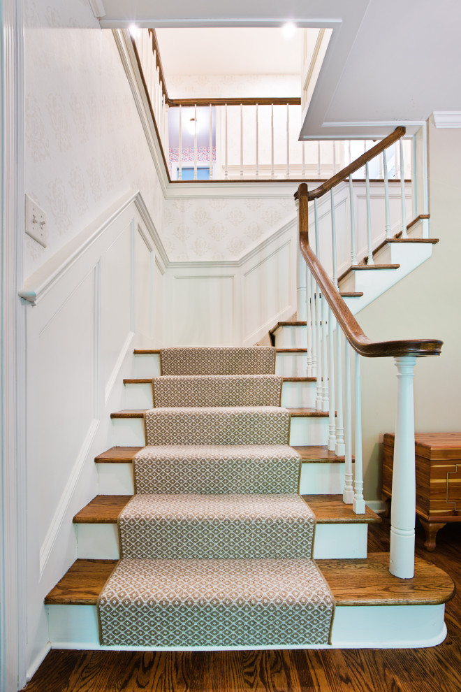 Ejemplo de escalera en L clásica de tamaño medio con escalones de madera, contrahuellas de madera, barandilla de madera y papel pintado