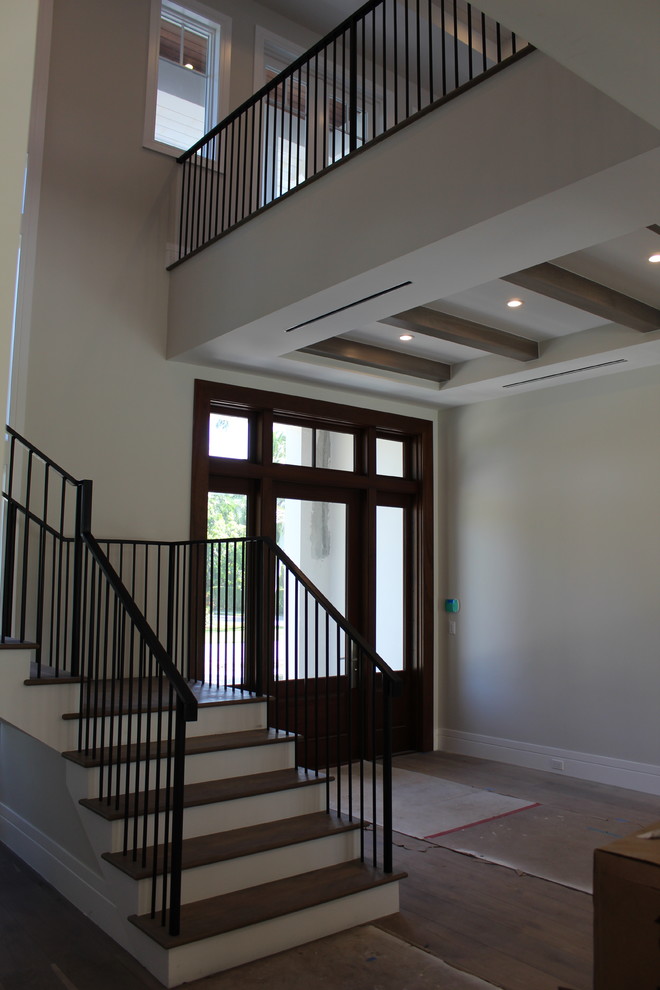 Ejemplo de escalera en L clásica renovada de tamaño medio con escalones de madera, contrahuellas de madera y barandilla de metal