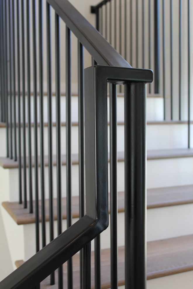 Esempio di una scala a "L" tradizionale di medie dimensioni con pedata in legno, alzata in legno e parapetto in metallo