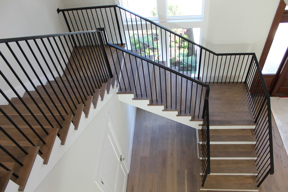 Inspiration for a mid-sized transitional wooden l-shaped metal railing staircase remodel in Other with wooden risers