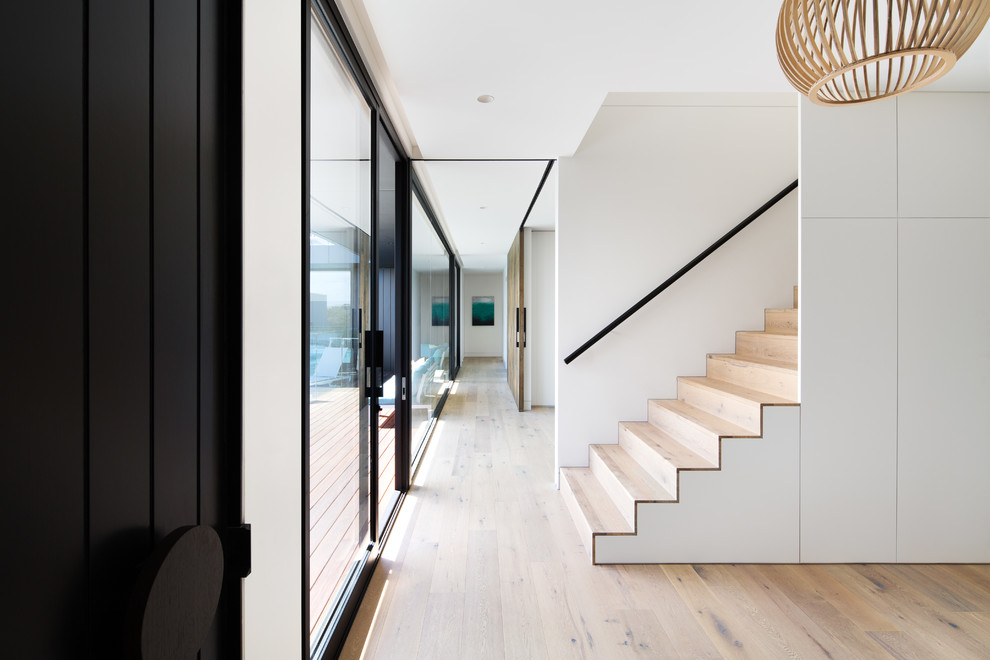Trendy wooden straight staircase photo in Melbourne with wooden risers