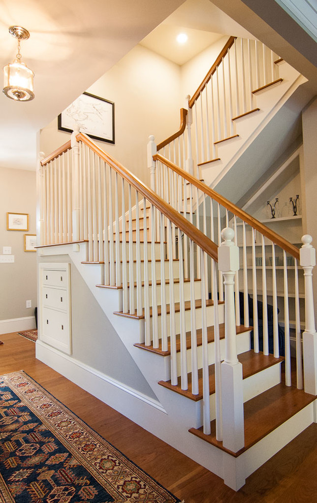 Design ideas for an expansive beach style wood u-shaped staircase in Portland Maine with painted wood risers.