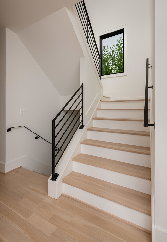 Foto de escalera en U moderna de tamaño medio con escalones de madera, contrahuellas de madera pintada y barandilla de metal