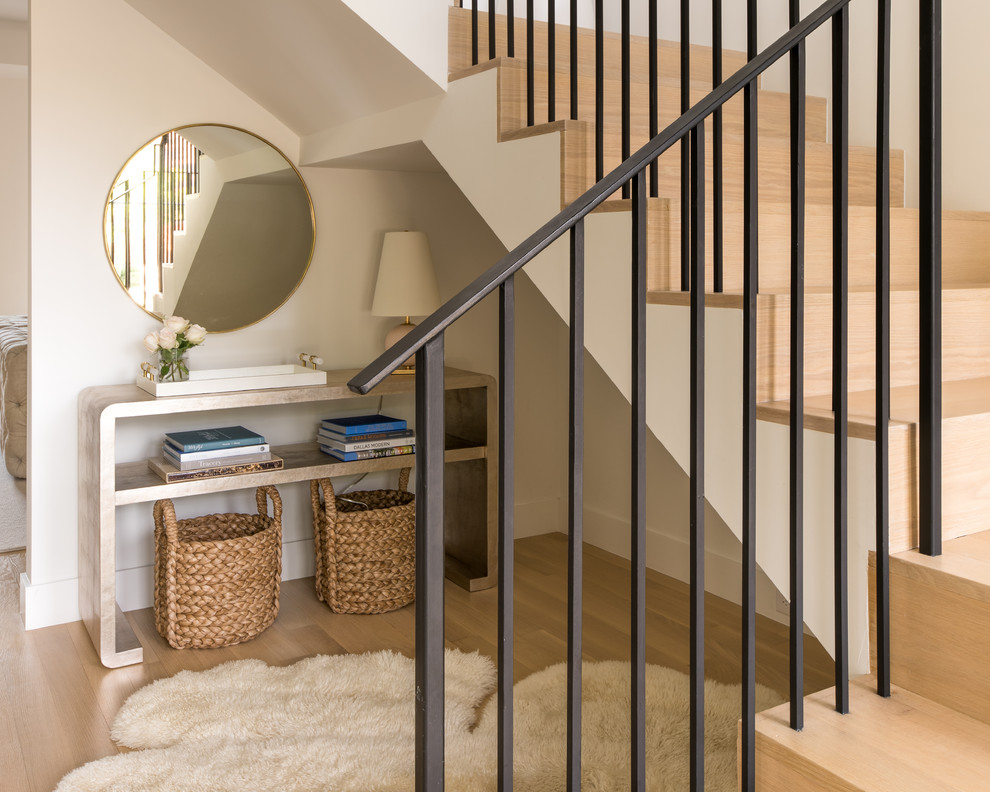 Ejemplo de escalera en L actual de tamaño medio con escalones de madera, contrahuellas de madera y barandilla de metal