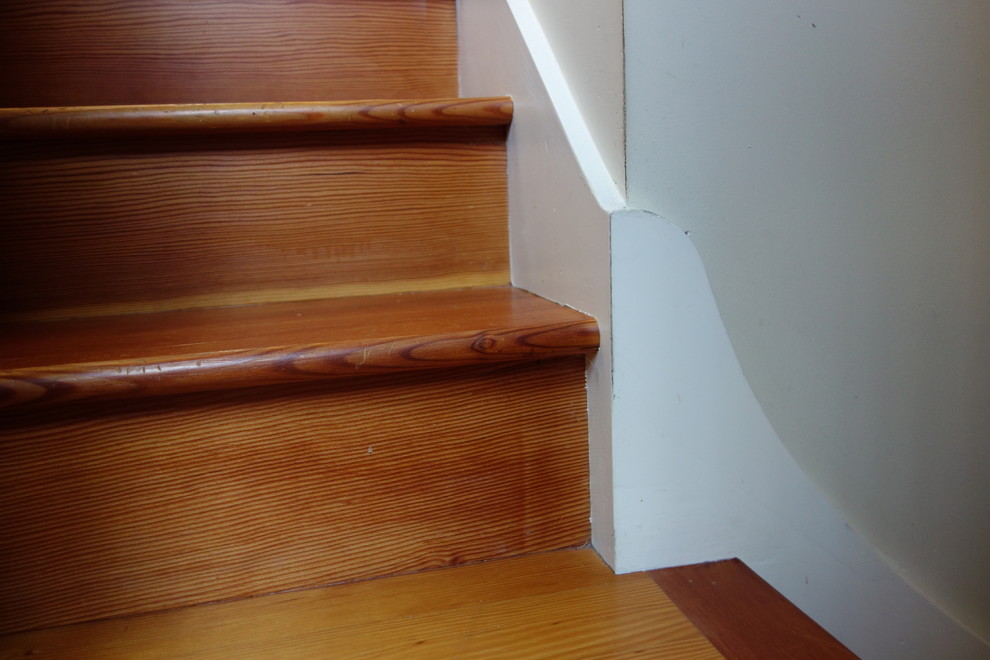 Diseño de escalera en L de estilo americano de tamaño medio con escalones de madera y contrahuellas de madera