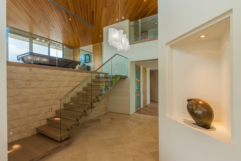 На фото: прямая лестница среднего размера в стиле модернизм с деревянными ступенями и стеклянными перилами без подступенок с