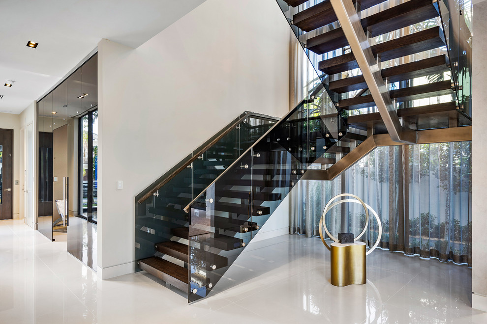 Идея дизайна: большая металлическая лестница на больцах в стиле модернизм с деревянными ступенями и стеклянными перилами