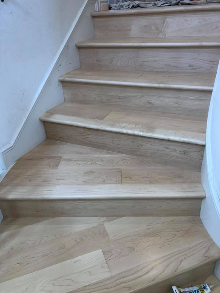 Diseño de escalera curva actual grande con escalones de madera, contrahuellas de madera y barandilla de madera