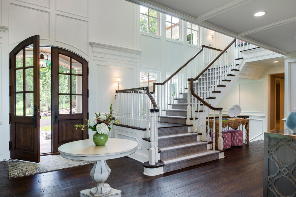 Пример оригинального дизайна: большая угловая лестница в морском стиле с деревянными перилами, деревянными ступенями и крашенными деревянными подступенками