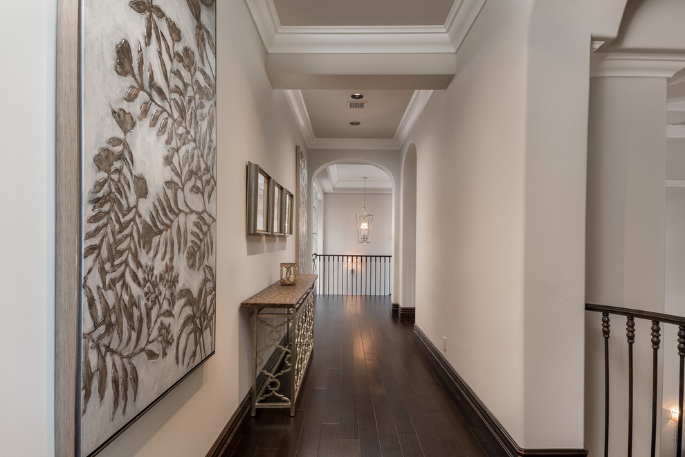 Example of a huge tuscan dark wood floor, white floor, tray ceiling and wall paneling hallway design in Phoenix with beige walls