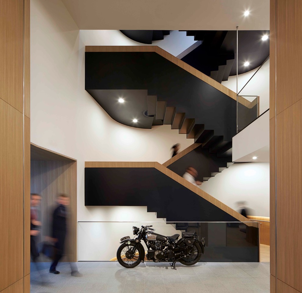 Diseño de escalera curva actual grande con escalones de madera y contrahuellas de madera