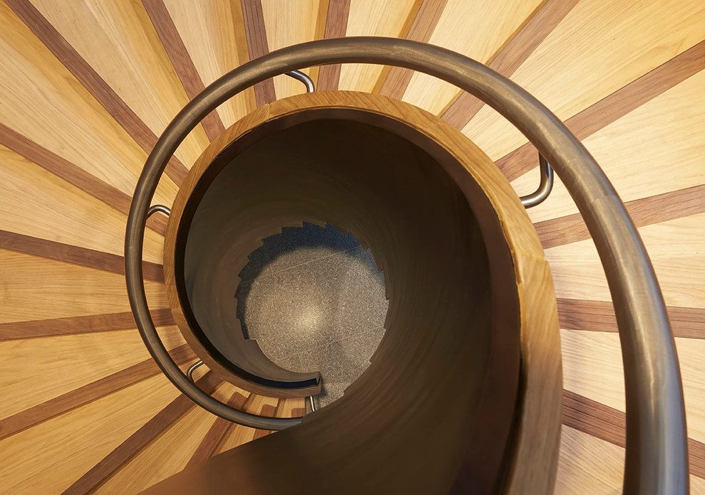 Aménagement d'un grand escalier courbe contemporain avec des marches en bois et des contremarches en bois.