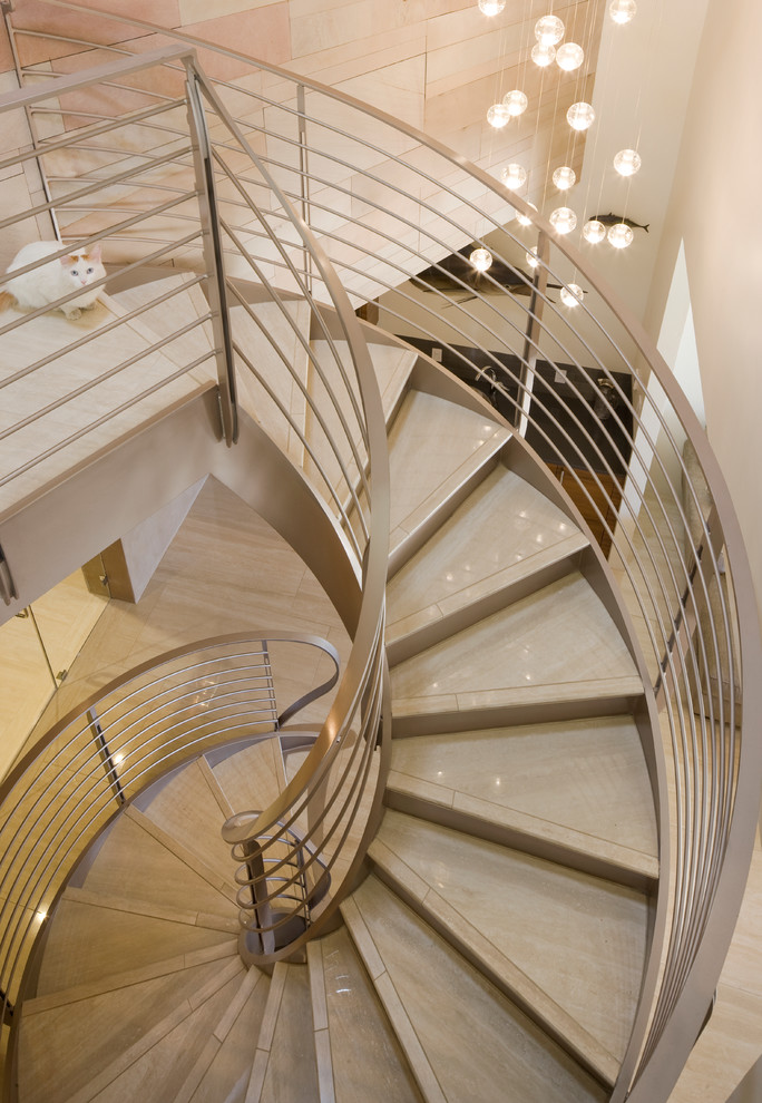 Idée de décoration pour un escalier carrelé hélicoïdal design avec un garde-corps en métal.