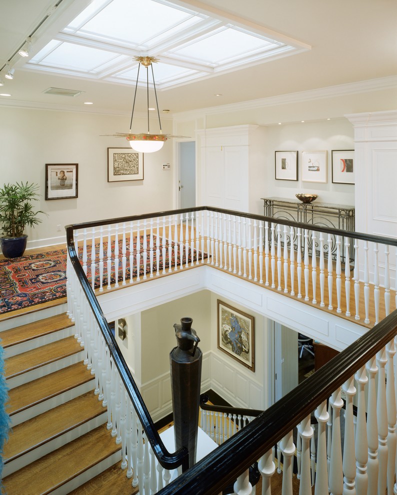 Example of a huge minimalist wooden u-shaped staircase design in Denver with painted risers