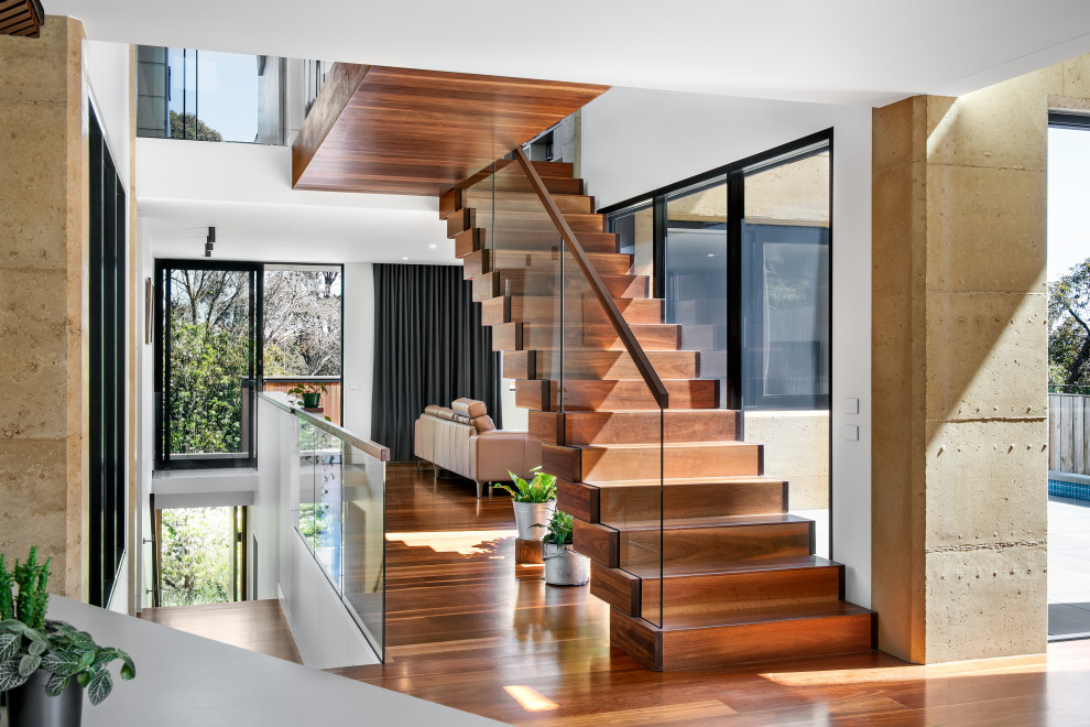 Идея дизайна: огромная прямая деревянная лестница в современном стиле с деревянными ступенями и стеклянными перилами