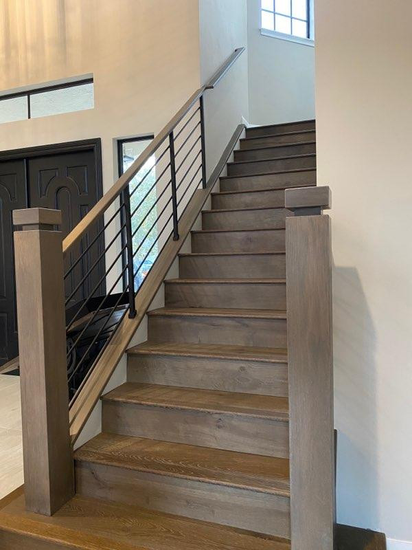 Diseño de escalera curva minimalista grande con escalones de madera pintada, contrahuellas de madera y barandilla de varios materiales