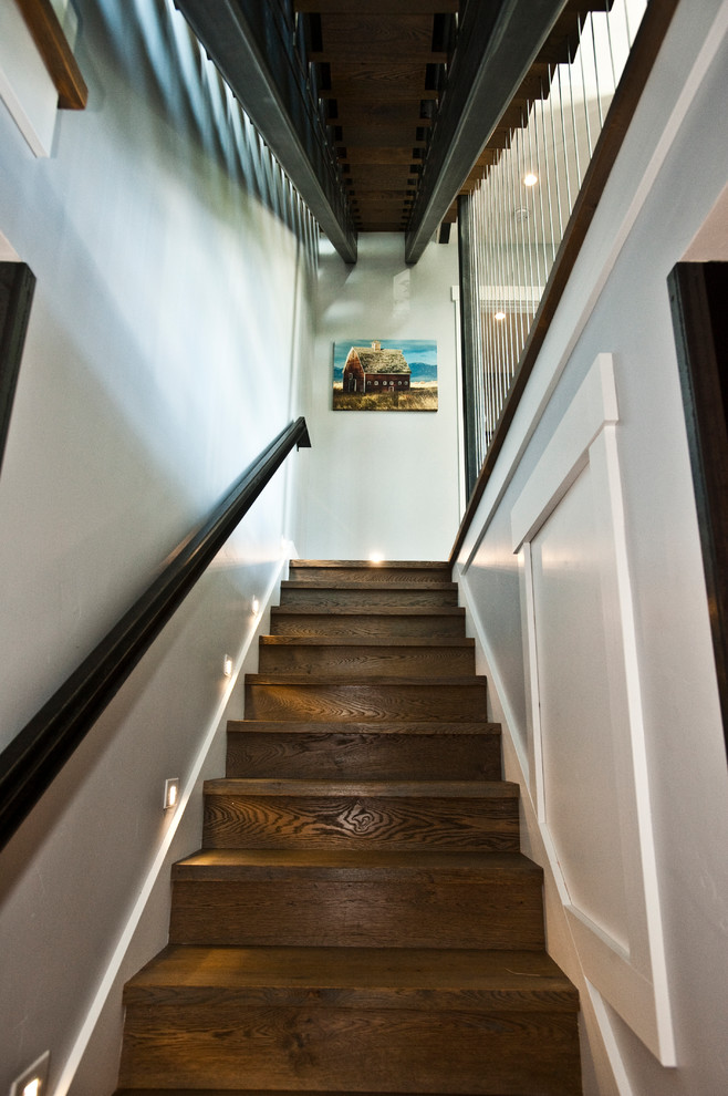 Ejemplo de escalera recta contemporánea grande con escalones de madera, barandilla de metal y contrahuellas de madera