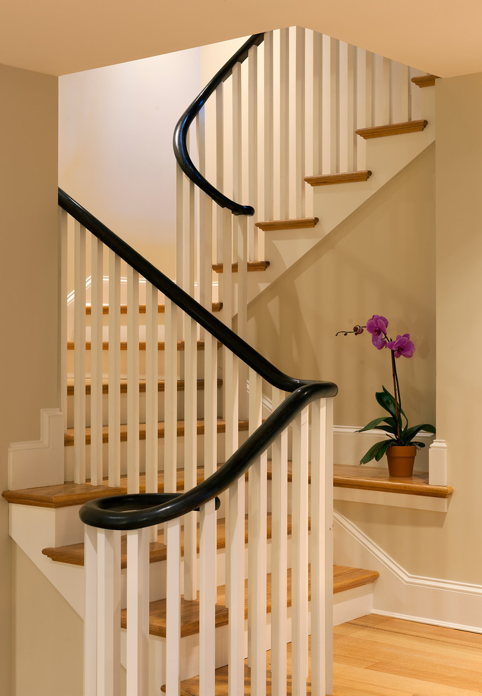 На фото: маленькая изогнутая лестница в классическом стиле с деревянными ступенями и крашенными деревянными подступенками для на участке и в саду