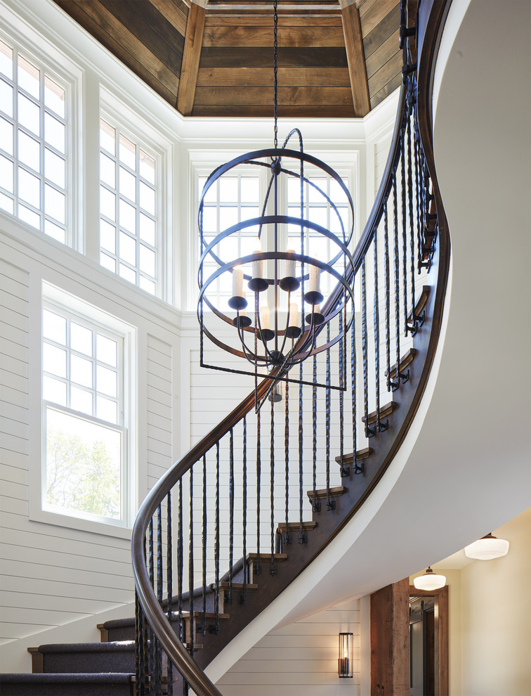 Стильный дизайн: большая изогнутая деревянная лестница в морском стиле с деревянными ступенями и перилами из смешанных материалов - последний тренд