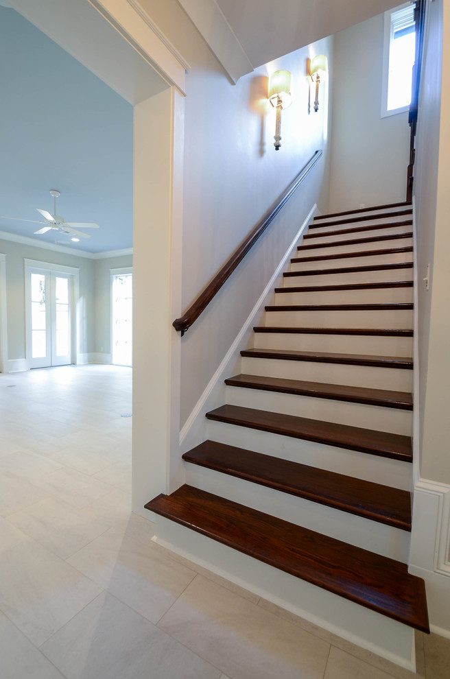 This is an example of a small traditional wood l-shaped staircase in New Orleans with painted wood risers.