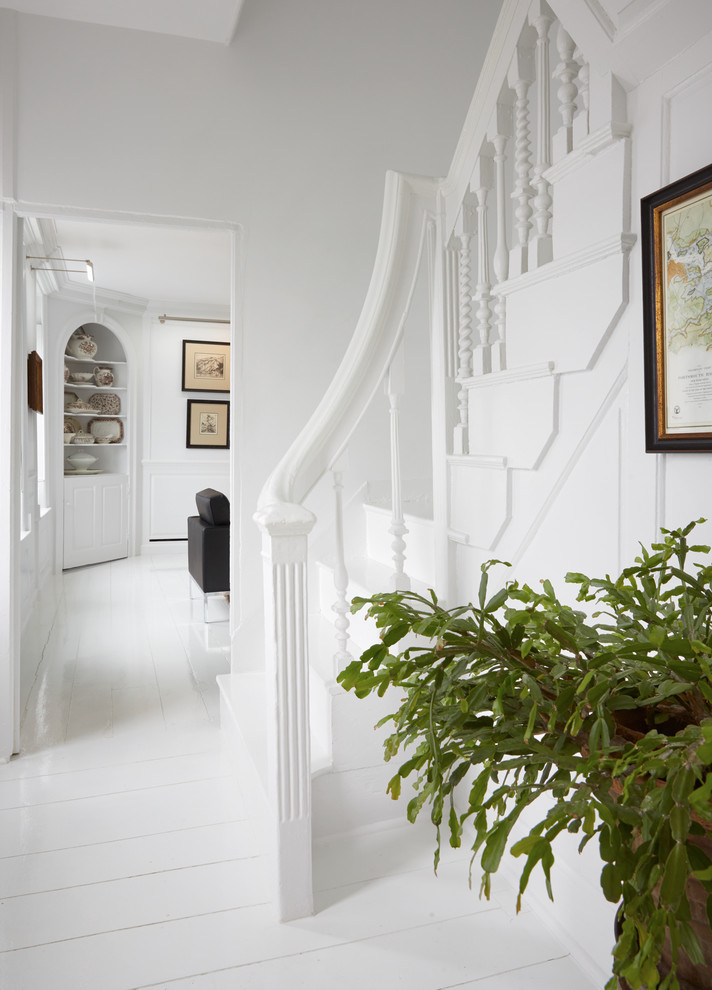 На фото: изогнутая лестница в стиле модернизм с крашенными деревянными ступенями, крашенными деревянными подступенками и деревянными перилами