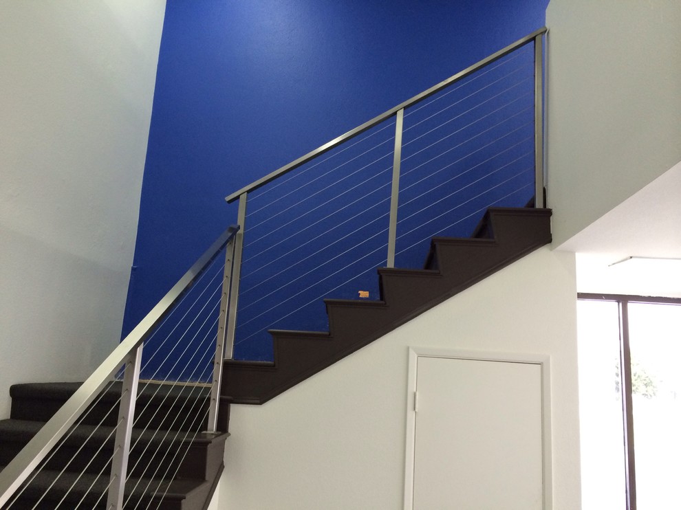 Example of a minimalist carpeted l-shaped staircase design in Orange County with carpeted risers