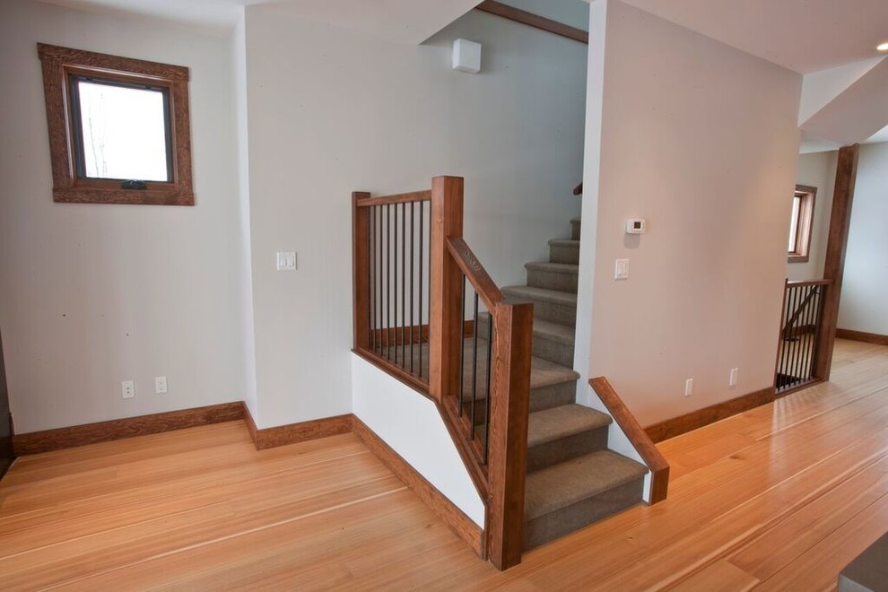 Exemple d'un escalier chic en L de taille moyenne avec des marches en moquette, des contremarches en moquette et un garde-corps en bois.