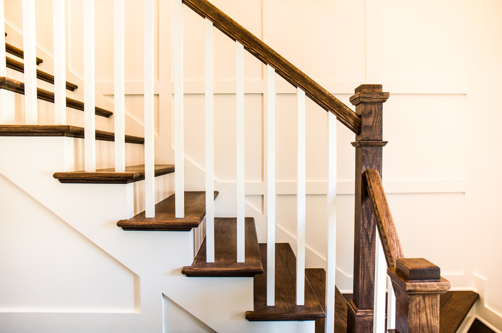 Diseño de escalera en L actual de tamaño medio con escalones de madera, contrahuellas de madera pintada y barandilla de madera