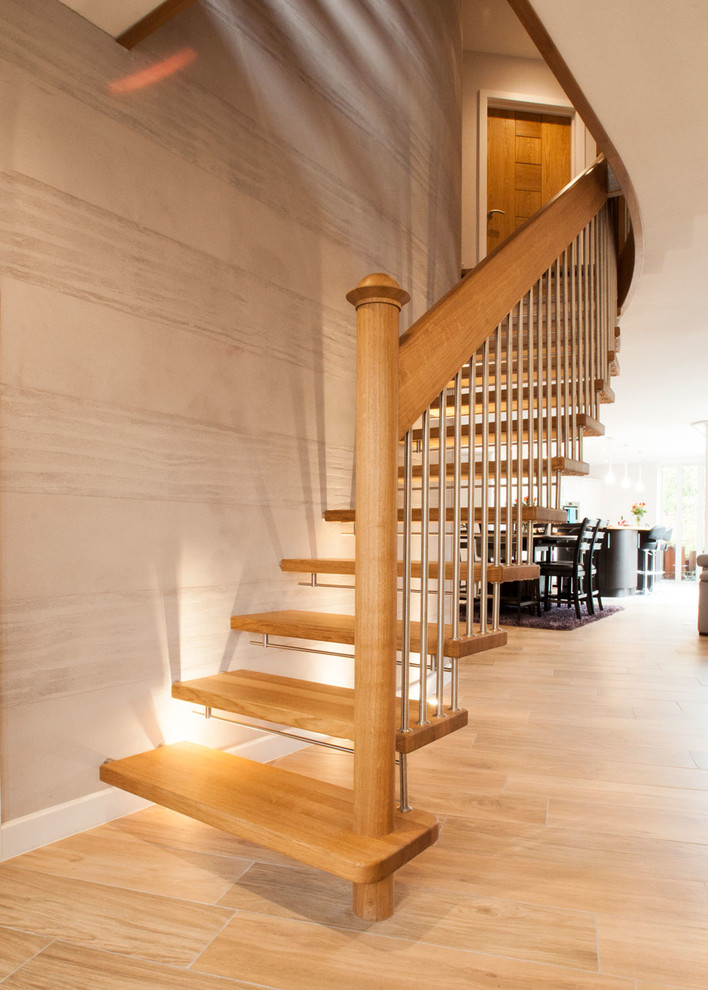 Inspiration för mellanstora moderna svängda trappor i trä, med sättsteg i trä och räcke i metall