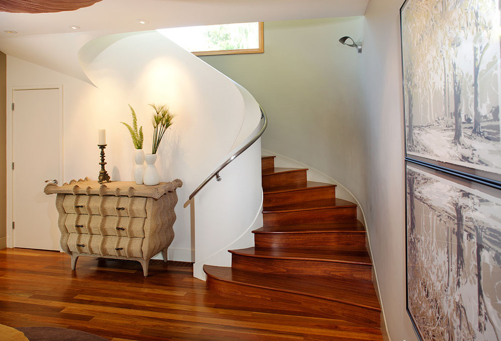 Foto de escalera curva contemporánea de tamaño medio con escalones de madera, contrahuellas de madera y barandilla de metal
