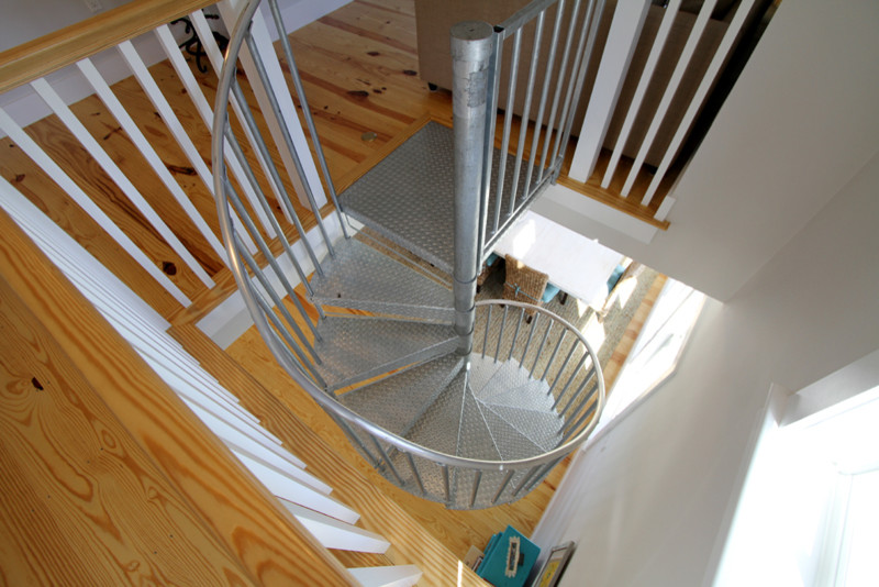 Ejemplo de escalera de caracol marinera de tamaño medio con escalones de madera y contrahuellas de madera pintada