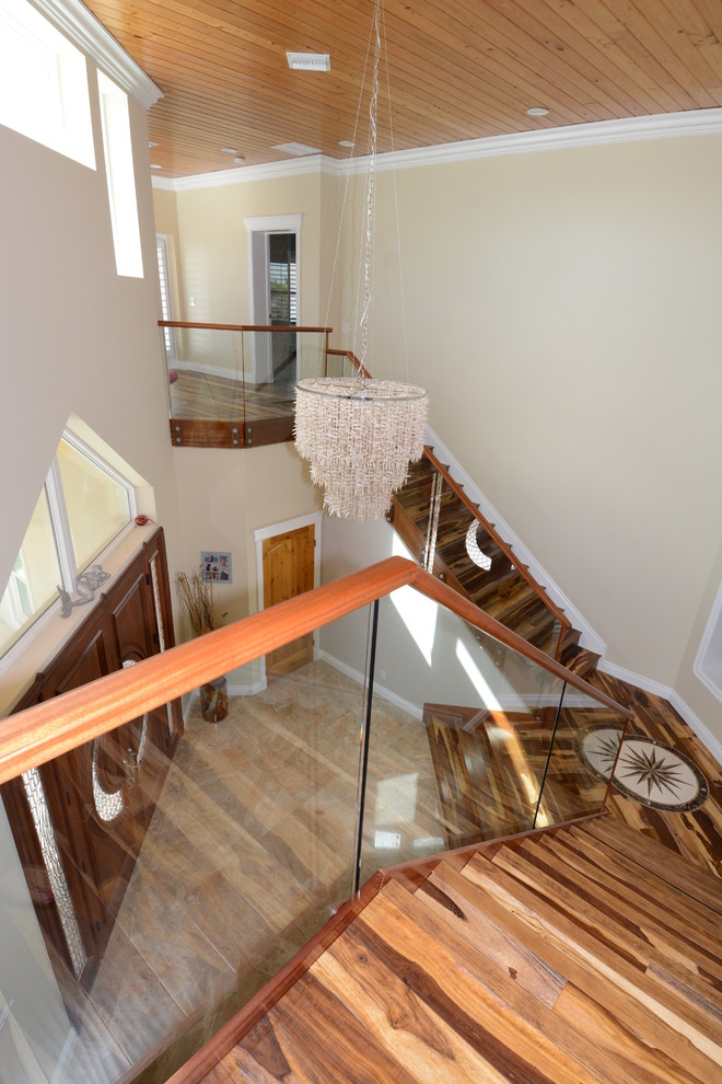 Modelo de escalera recta costera grande con escalones de madera, contrahuellas de madera y barandilla de vidrio
