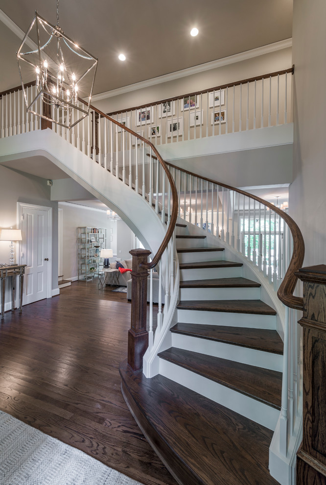 Imagen de escalera curva clásica renovada de tamaño medio con escalones de madera y contrahuellas de madera pintada