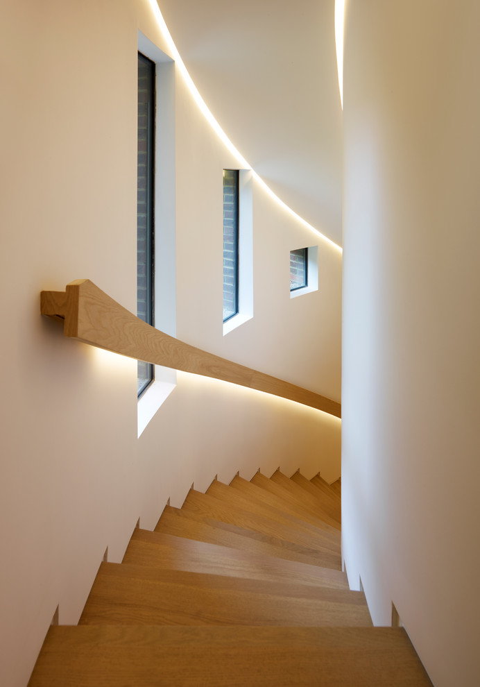 Imagen de escalera curva actual con escalones de madera