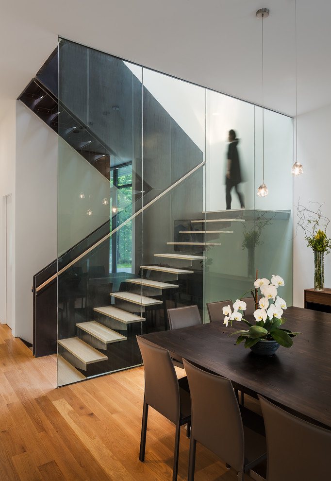 Idée de décoration pour un escalier flottant design avec des marches en bois et des contremarches en métal.