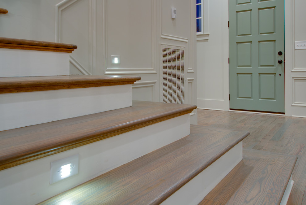 Aménagement d'un grand escalier peint classique en L avec des marches en bois.