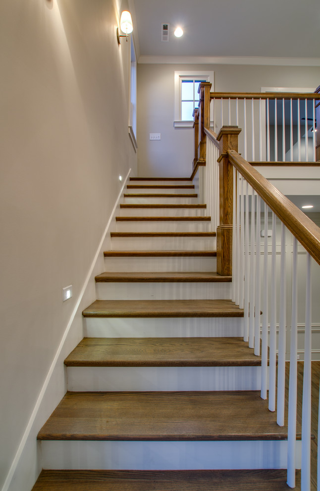 Imagen de escalera en L tradicional grande con escalones de madera y contrahuellas de madera pintada