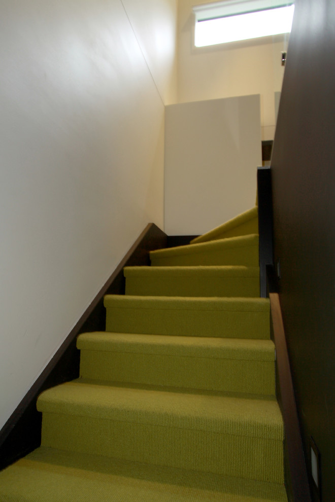 Inspiration pour un petit escalier minimaliste en L avec des marches en moquette et des contremarches en moquette.