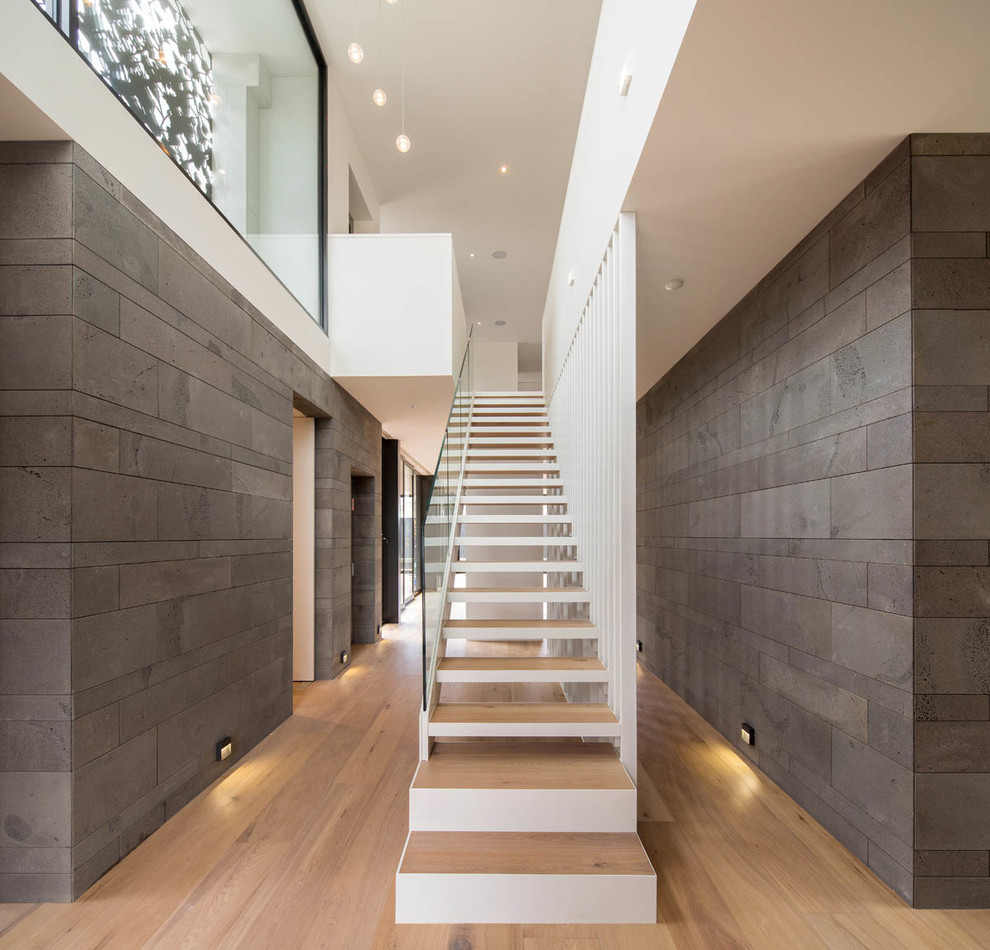 Cette photo montre un grand escalier peint droit tendance avec des marches en bois.