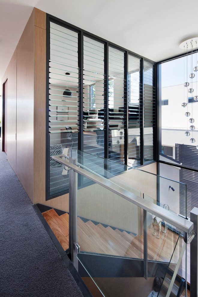 Свежая идея для дизайна: лестница в стиле модернизм с деревянными ступенями - отличное фото интерьера