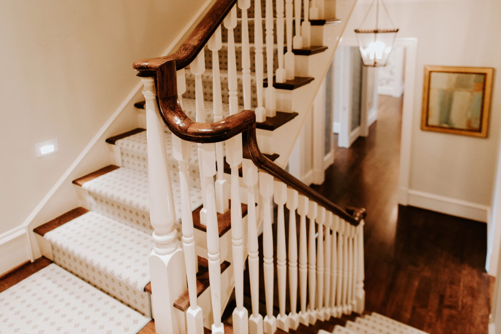 На фото: п-образная лестница среднего размера в стиле неоклассика (современная классика) с крашенными деревянными ступенями, крашенными деревянными подступенками и деревянными перилами
