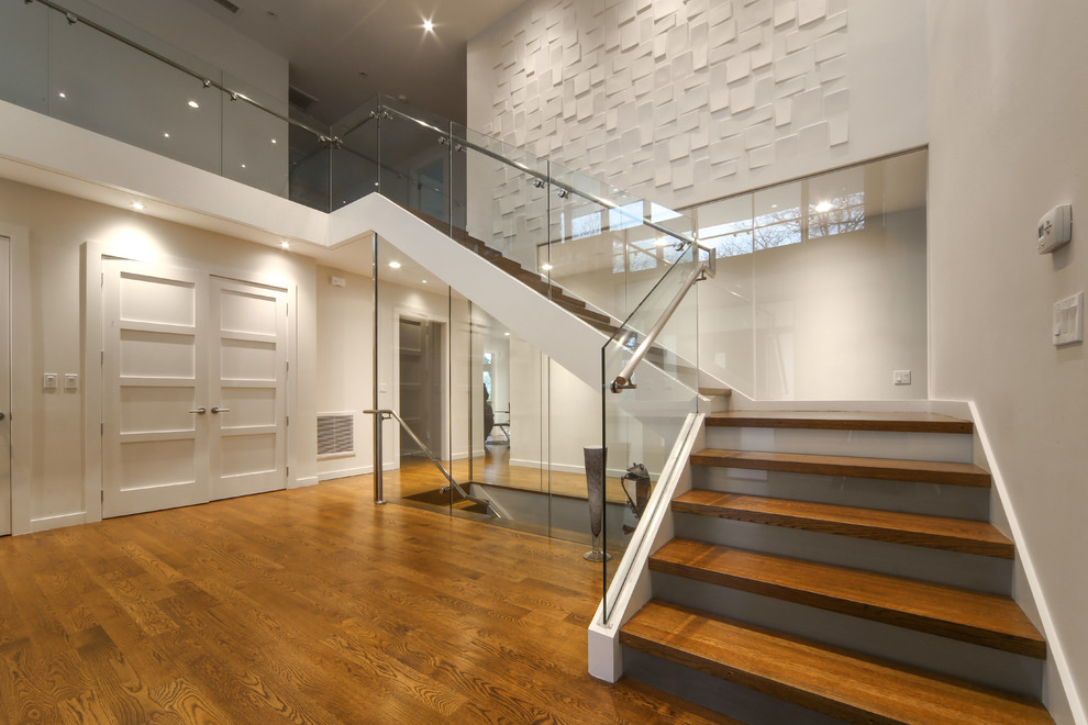 Пример оригинального дизайна: большая угловая лестница в стиле модернизм с деревянными ступенями, стеклянными подступенками и стеклянными перилами